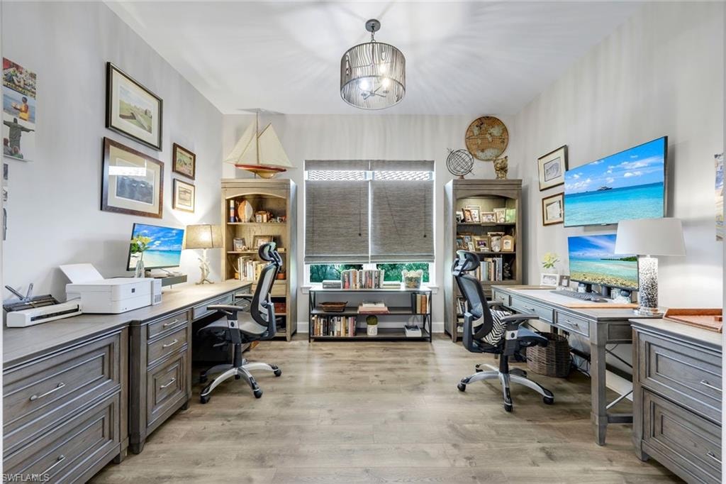 Dedicated office space featuring wood-finish flooring, recessed lighting, and a contemporary chandelier