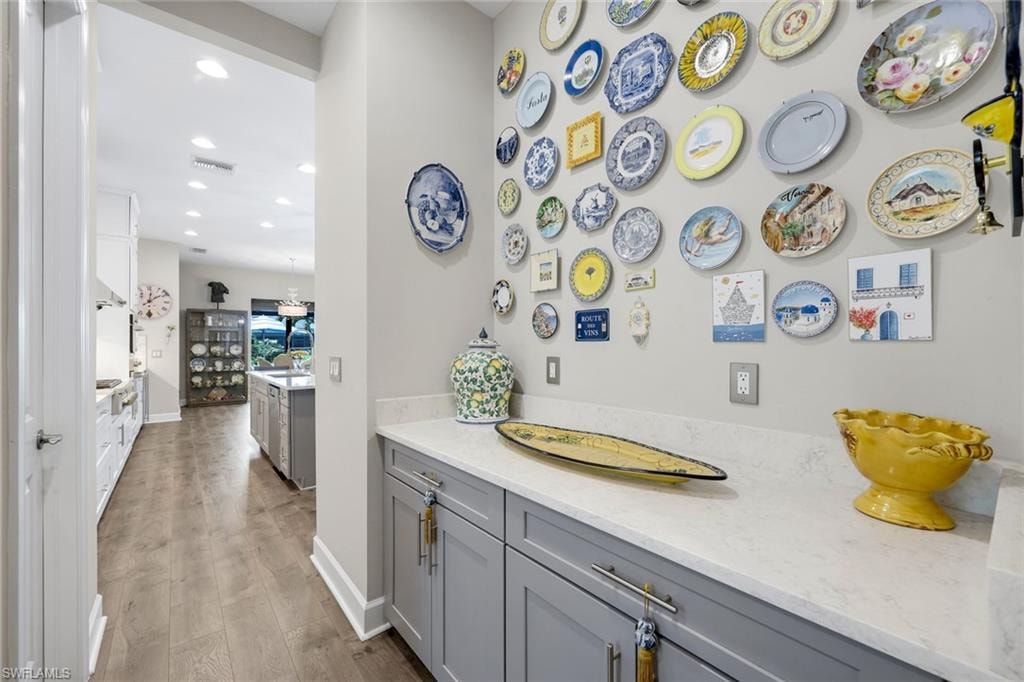 Custom cabinetry with light gray finish, polished hardware, and white countertops