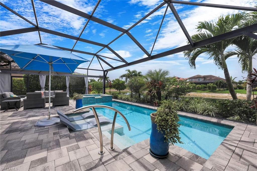 Screened lanai featuring a swimming pool, hot tub, and paver patio