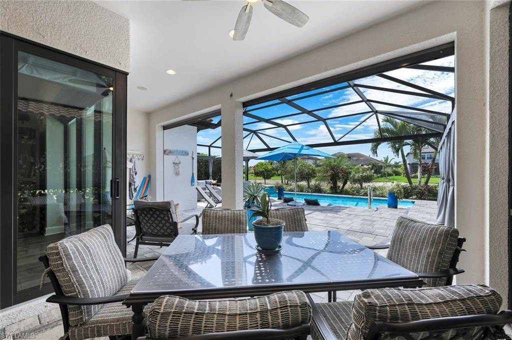 Screened lanai featuring a ceiling fan, recessed lighting, and a paved patio area