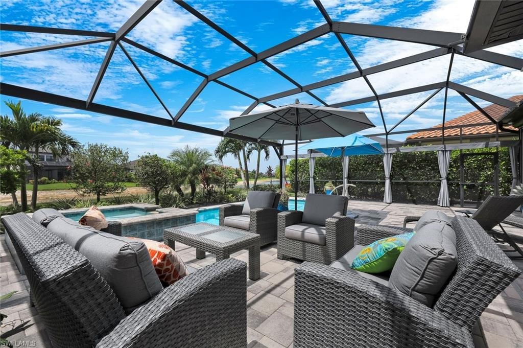 Screened lanai featuring a paver patio, integrated spa, and mature landscaping