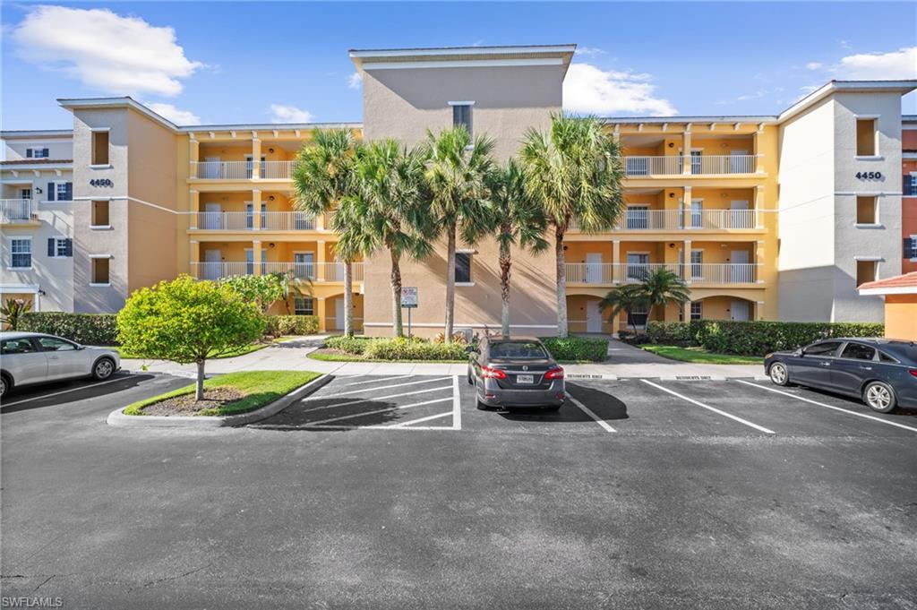 View of apartment building / complex with uncovered parking