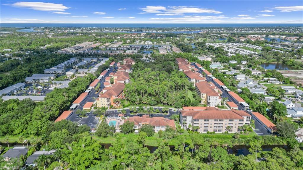 Aerial overview of property's location featuring a large body of water and a tree filled landscape