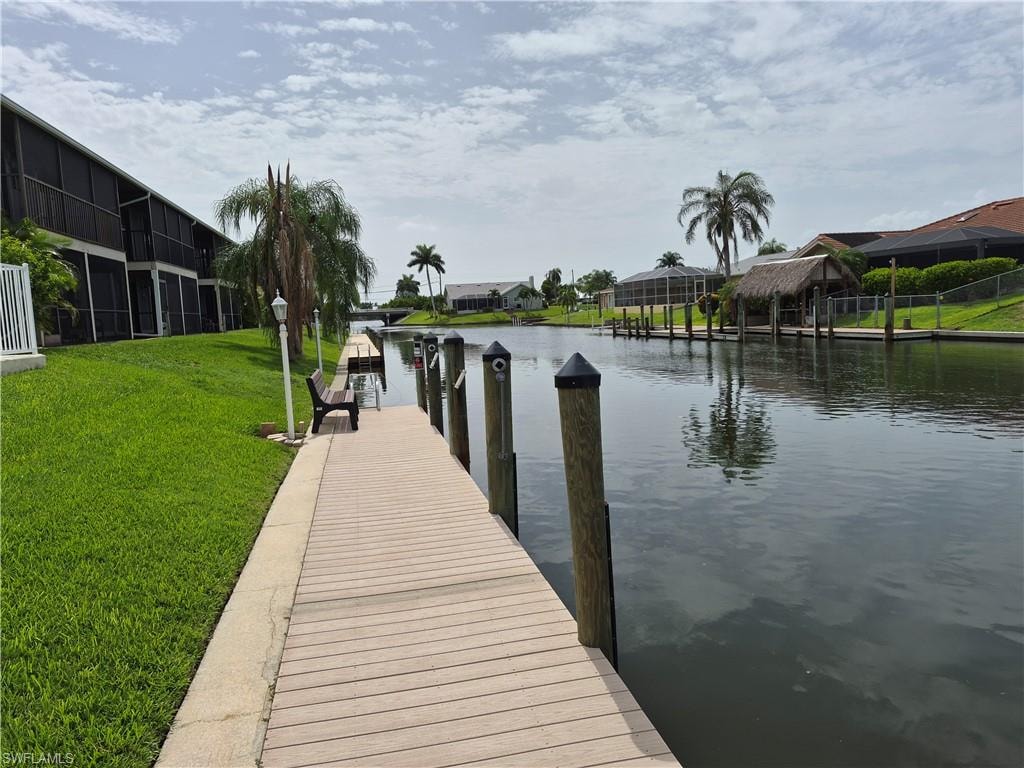 Canal-front property with a private dock featuring multiple pilings