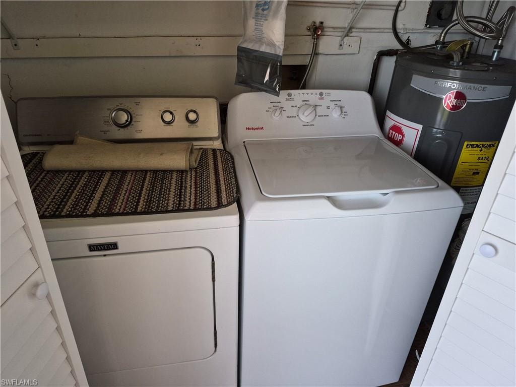 Dedicated laundry area featuring a white top-loading washing machine, a white front-loading dryer, and a water heater