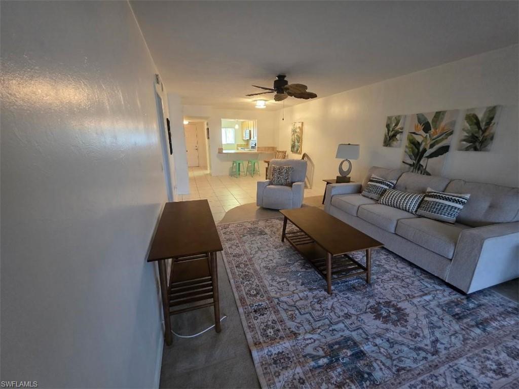 Open concept living area featuring light-toned walls and tile flooring
