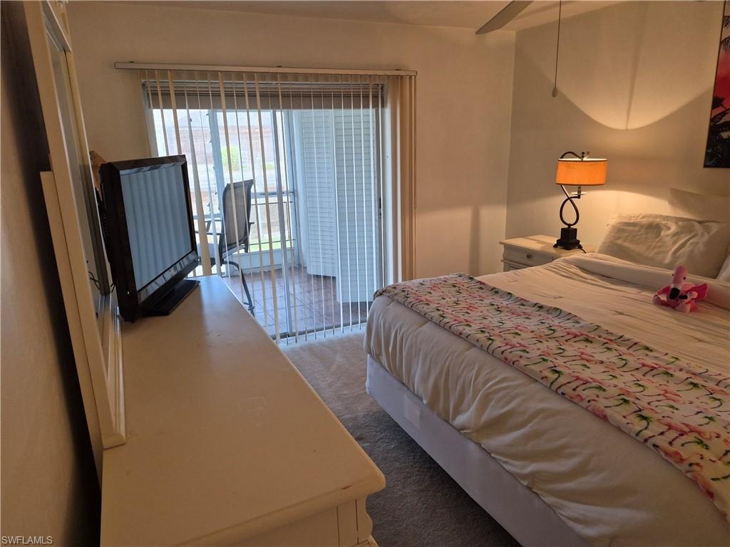 Carpeted room featuring vertical blinds on sliding glass doors opening to a balcony