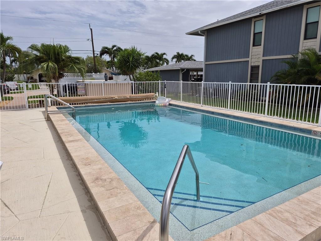 Rectangular swimming pool featuring a light blue interior finish and stainless steel handrails