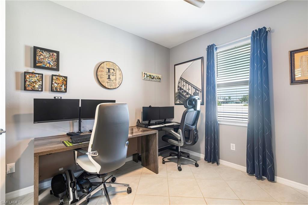 Versatile room featuring light grey walls, tile flooring, a window with horizontal blinds, and a ceiling fan