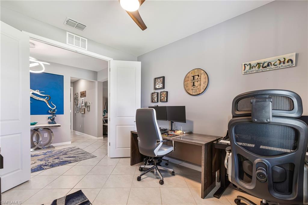 Interior room featuring light gray walls, white trim, and neutral tile flooring
