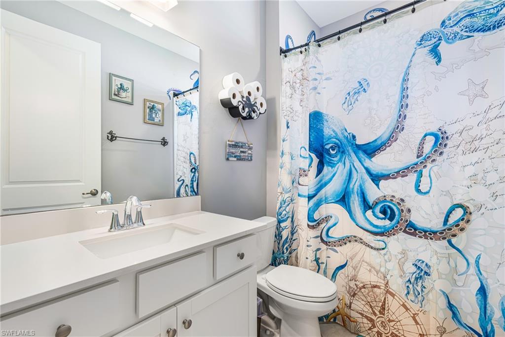 White vanity with integrated sink, chrome faucet, and rectangular mirror