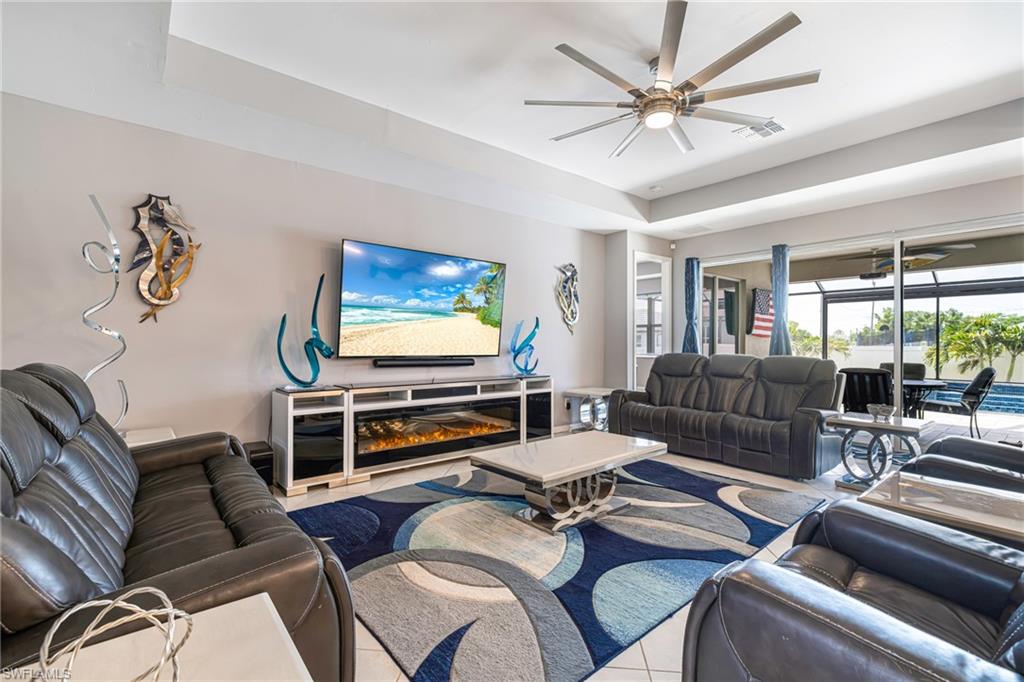 Spacious living area featuring a large television console with an integrated electric fireplace