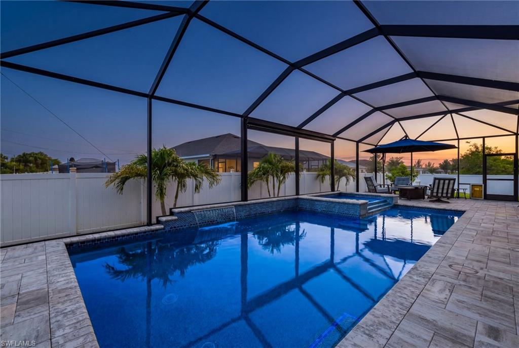 Screened lanai featuring a swimming pool, integrated spa, and paver decking
