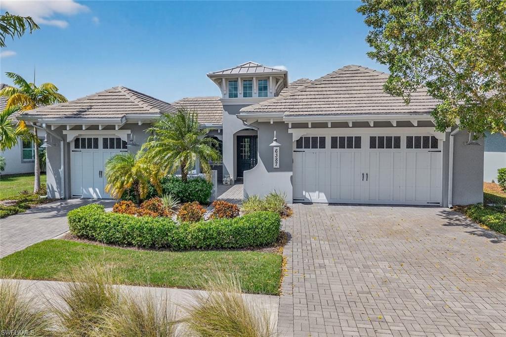 Beautiful coastal elevation with three-car garage and inviting front courtyard entrance.