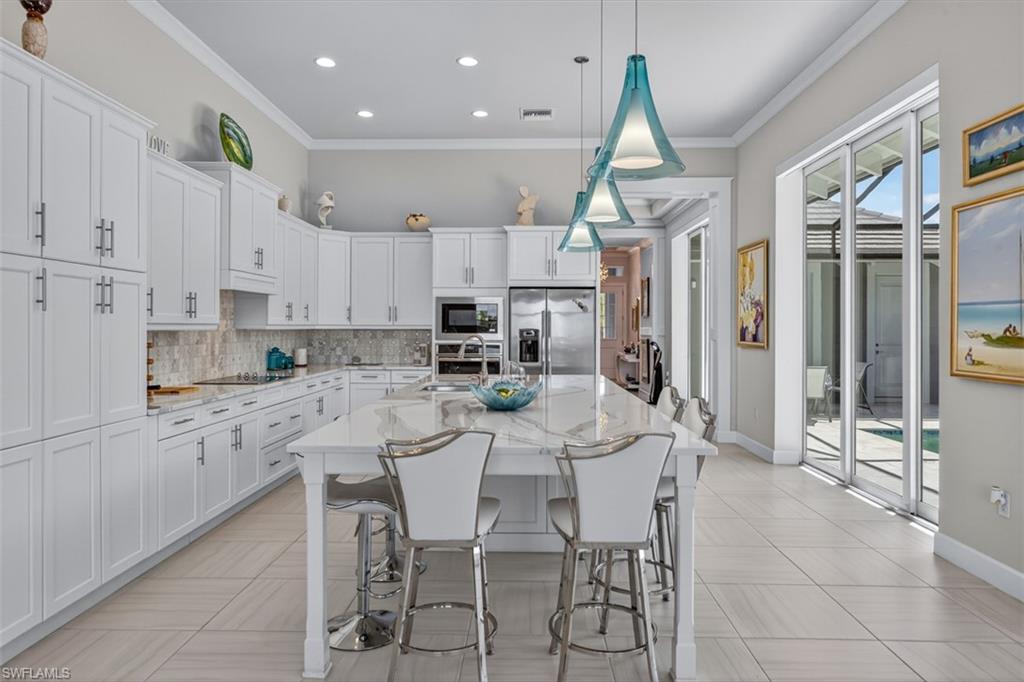 A chef-inspired kitchen featuring an oversized quartz island, abundant custom cabinetry, premium appliances, and effortless flow to the outdoor living spaces.