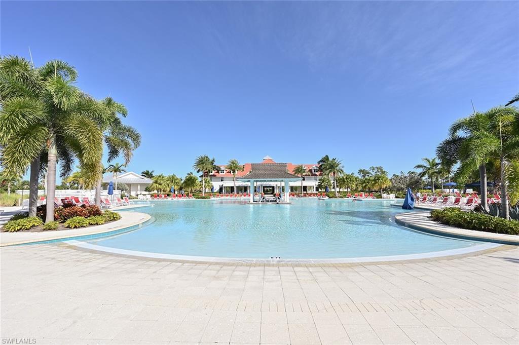 Vacation is part of everyday life with a spectacular resort-style pool surrounded by swaying palms, comfortable lounging areas, and tropical landscaping.