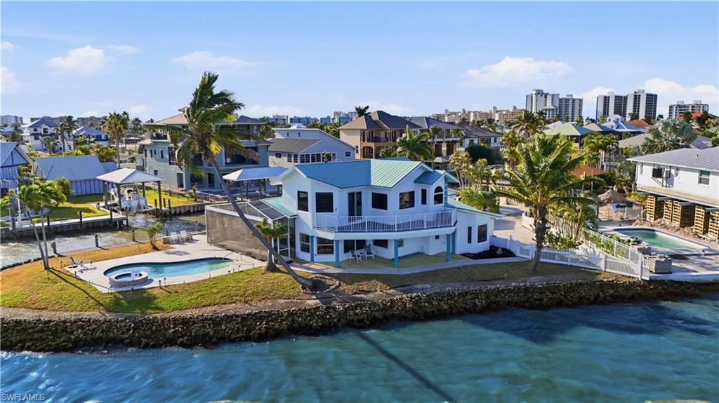Aerial view of residential area with a pool and a large body of water - Virtually Edited Image