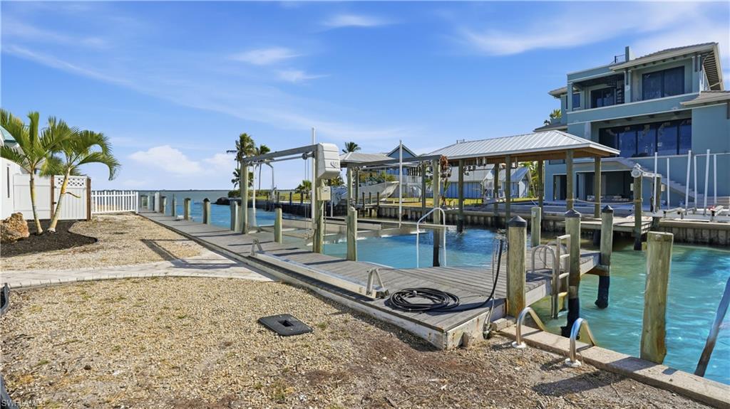 Dock area with boat lift and a water view - Virtually Edited Image