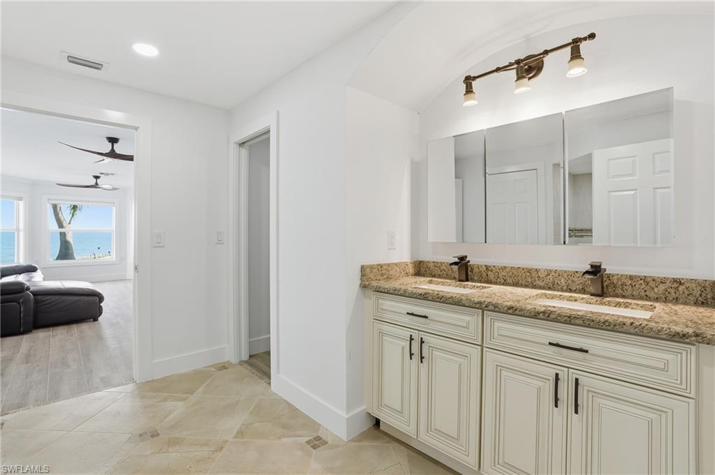 Ensuite bathroom featuring double vanity and light wood-style floors - Virtually Edited Image
