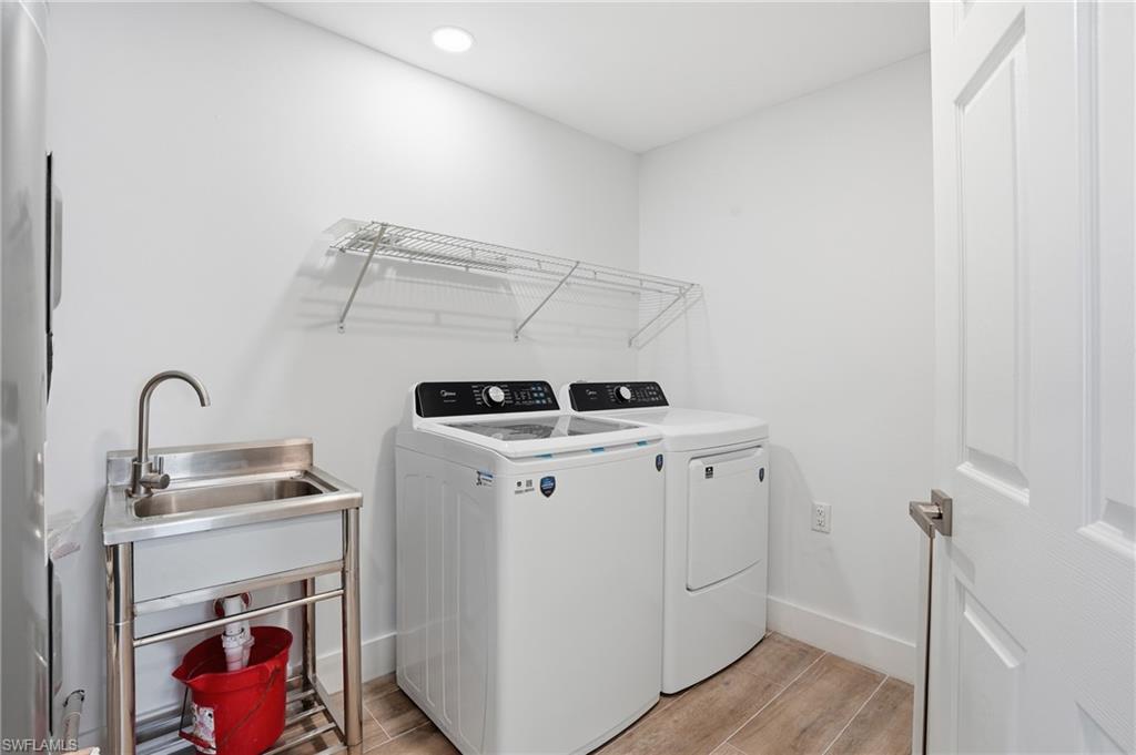 Laundry area featuring wood tiled floors and separate washer and dryer - Virtually Edited Image