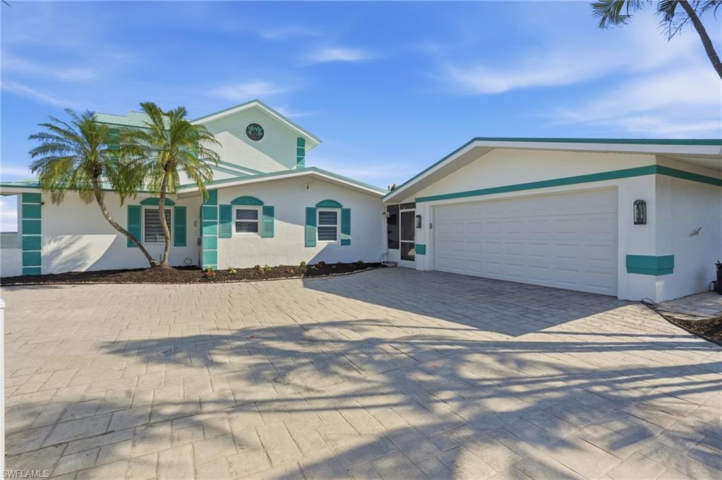 Ranch-style house featuring stucco siding and decorative driveway - Virtually Edited Image