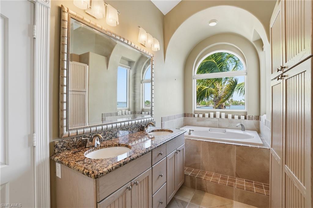 Full bathroom with double vanity, a garden tub, and healthy amount of natural light - Virtually Edited Image
