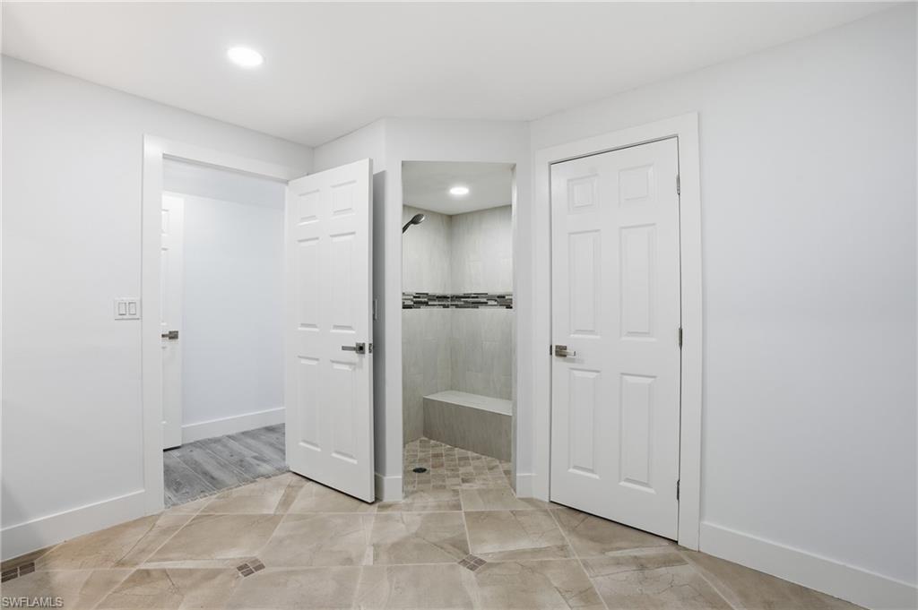Full bath featuring tiled shower, recessed lighting, and light tile patterned flooring - Virtually Edited Image