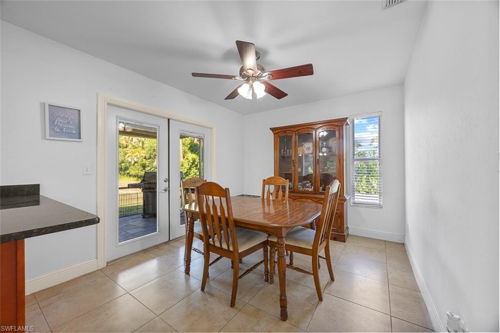 Dining area featuring tile flooring, a ceiling fan, and white walls