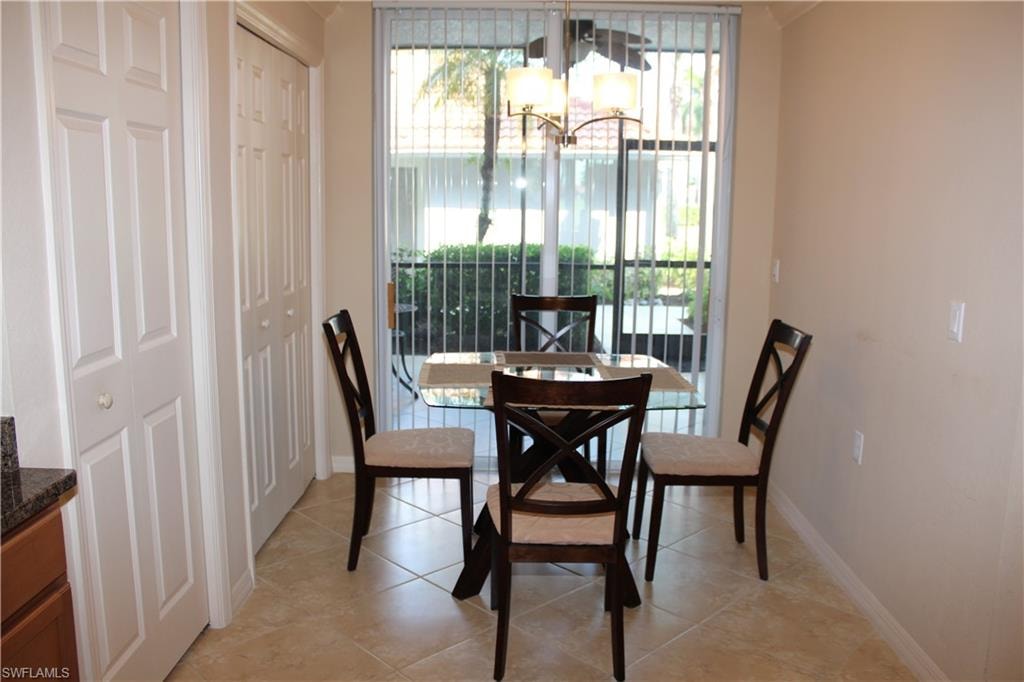 Dining room with a chandelier and light tile patterned flooring