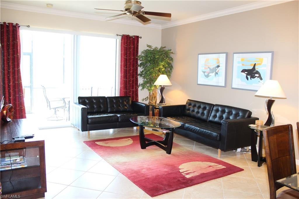 Living area featuring ornamental molding, light tile patterned flooring, and ceiling fan