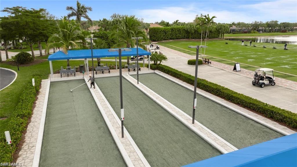 View of property's community featuring a yard, a water view, and a game area