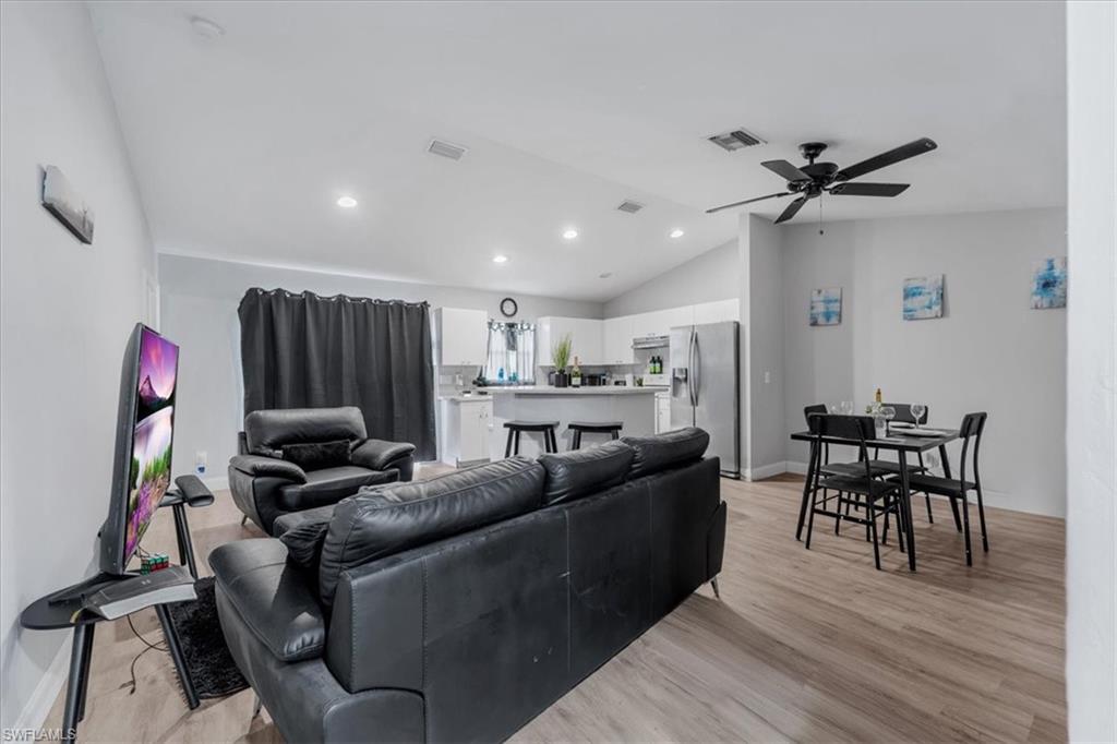 Open-concept living space featuring wood-finish flooring, recessed lighting, and a modern ceiling fan