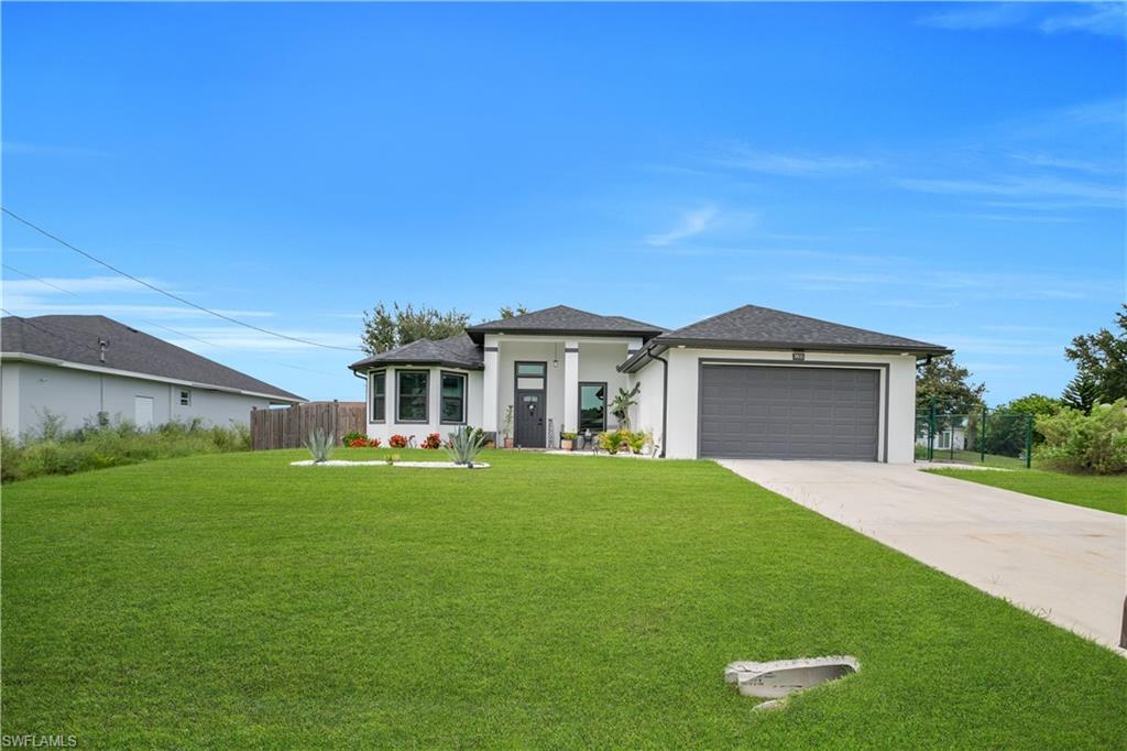 Modern single-story residence featuring a white stucco exterior, black shingle roof, and an attached two-car garage with a dark gray door