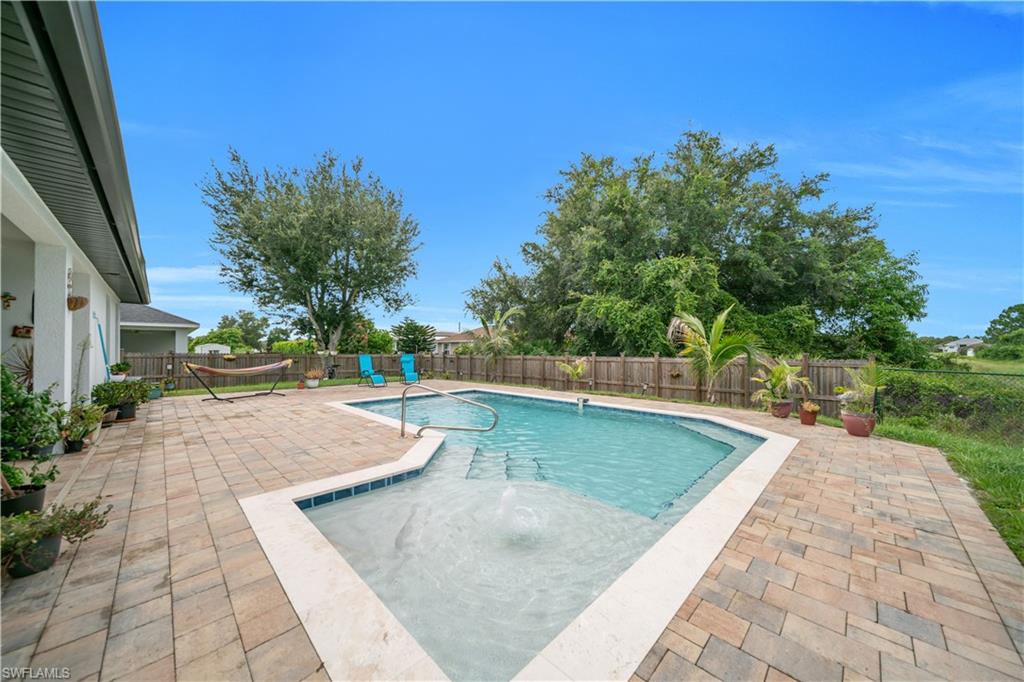 In-ground pool featuring integrated steps and a bubbler, surrounded by a paver patio