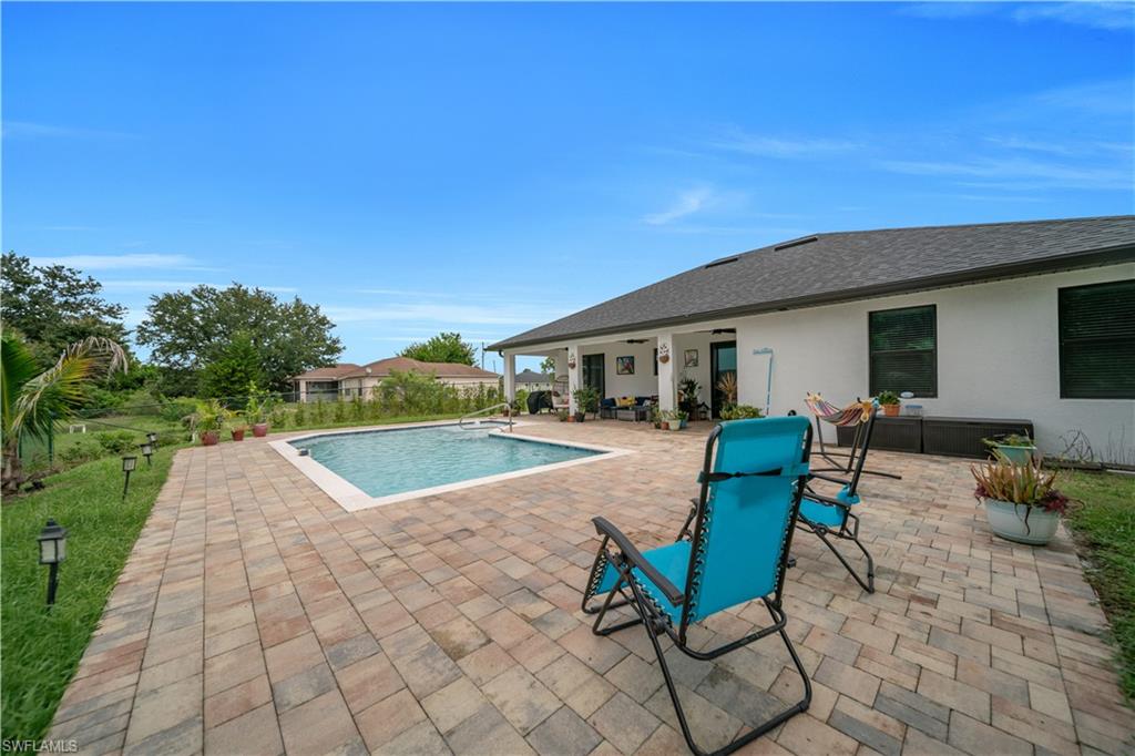 Rectangular in-ground swimming pool with a surrounding paver patio and a covered lanai