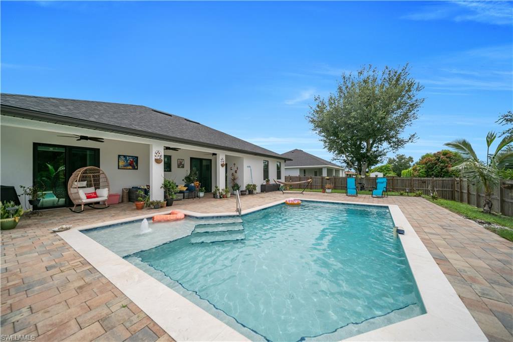 Rectangular inground pool featuring an integrated spa with a fountain and a wide entry step