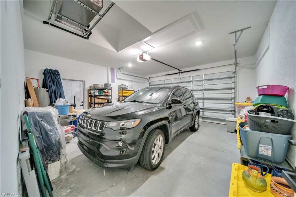 Two-car garage featuring a concrete floor, white walls, and an overhead door