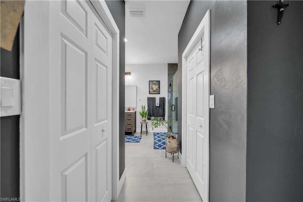Hallway featuring white bi-fold doors and dark gray walls