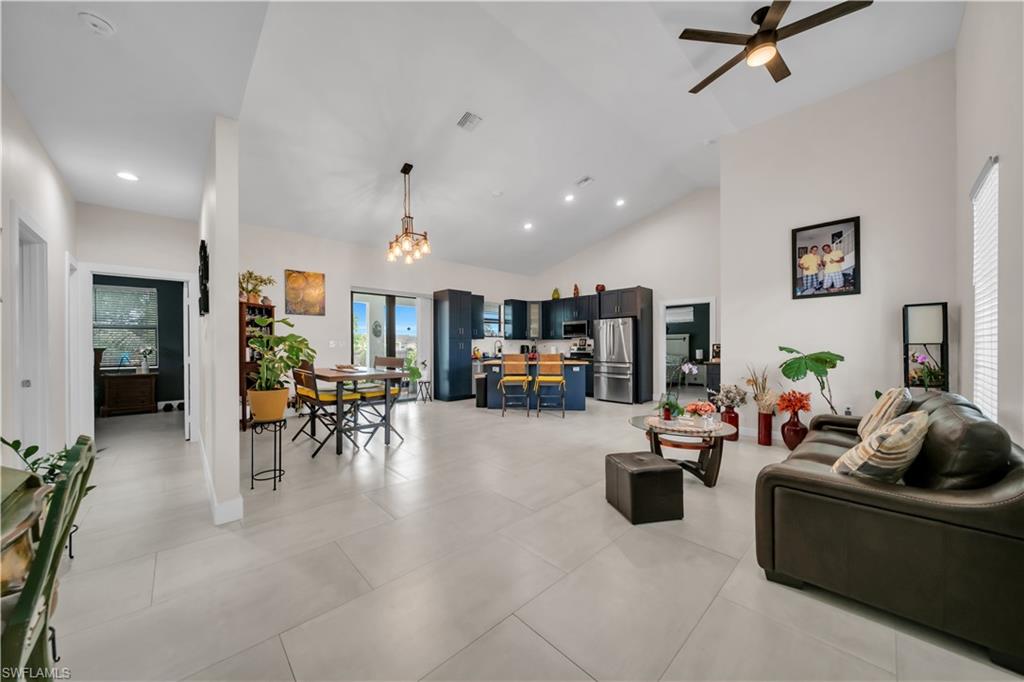 Vaulted ceilings define this open-concept interior featuring light-toned tile flooring throughout