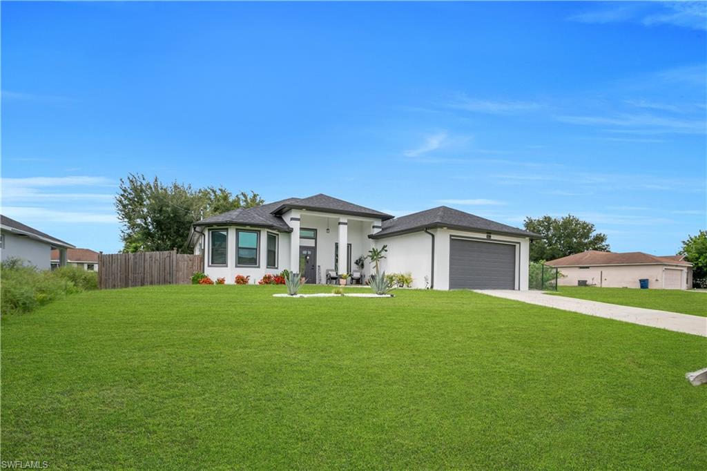 Modern white stucco exterior with a dark gray garage door and a covered front entry