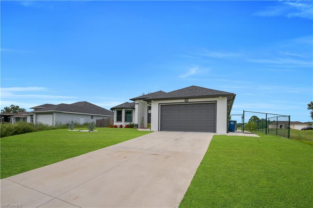 Contemporary single-story residence with a concrete driveway, attached garage, and a fenced side yard