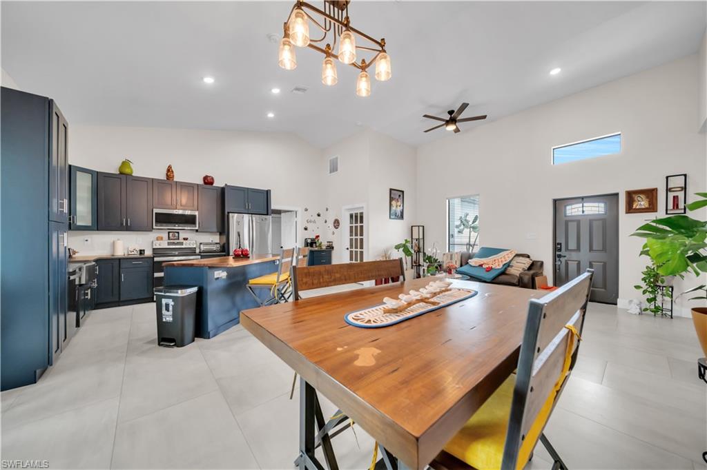 Open-concept interior featuring high vaulted ceilings and light tile flooring