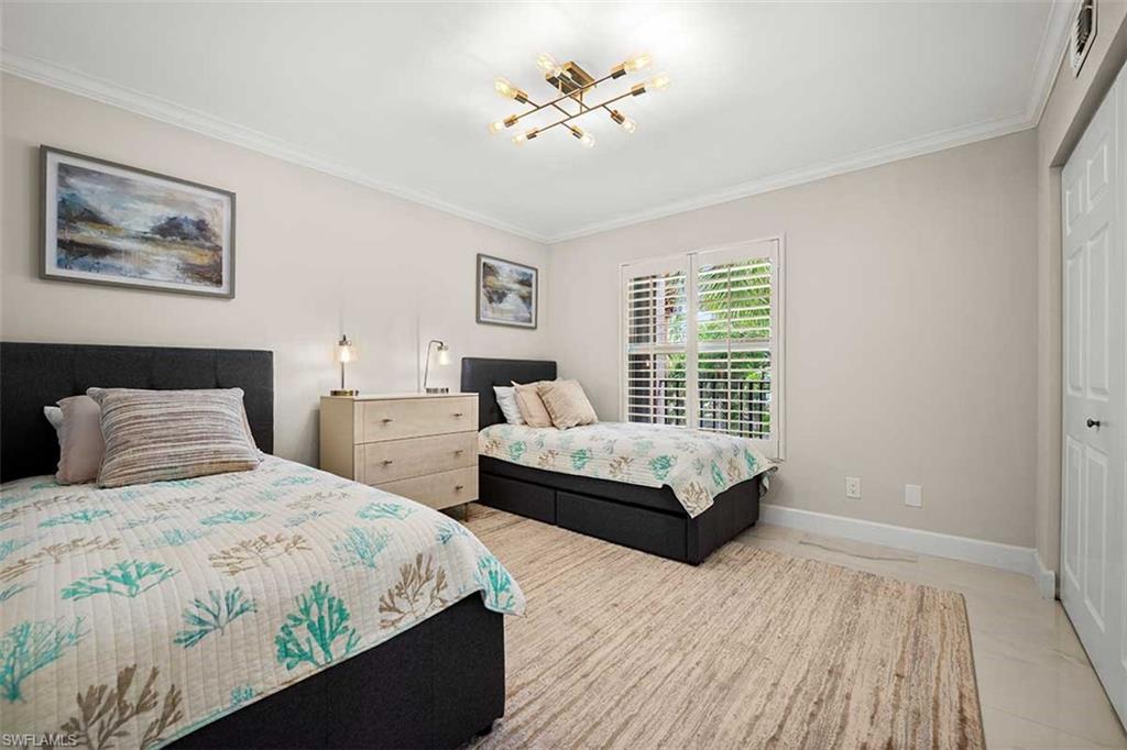 Interior room with crown molding, a contemporary ceiling light fixture, and light-toned walls