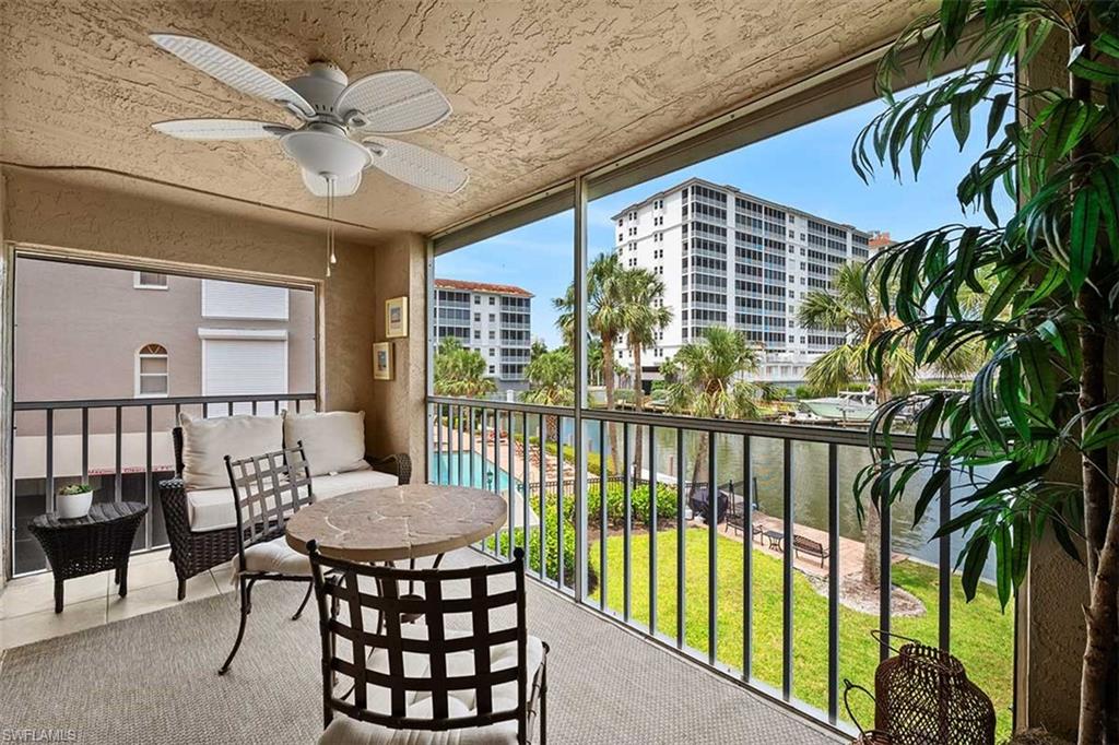 Screened balcony featuring a ceiling fan with integrated lighting, textured ceiling finish, and a neutral tone floor covering