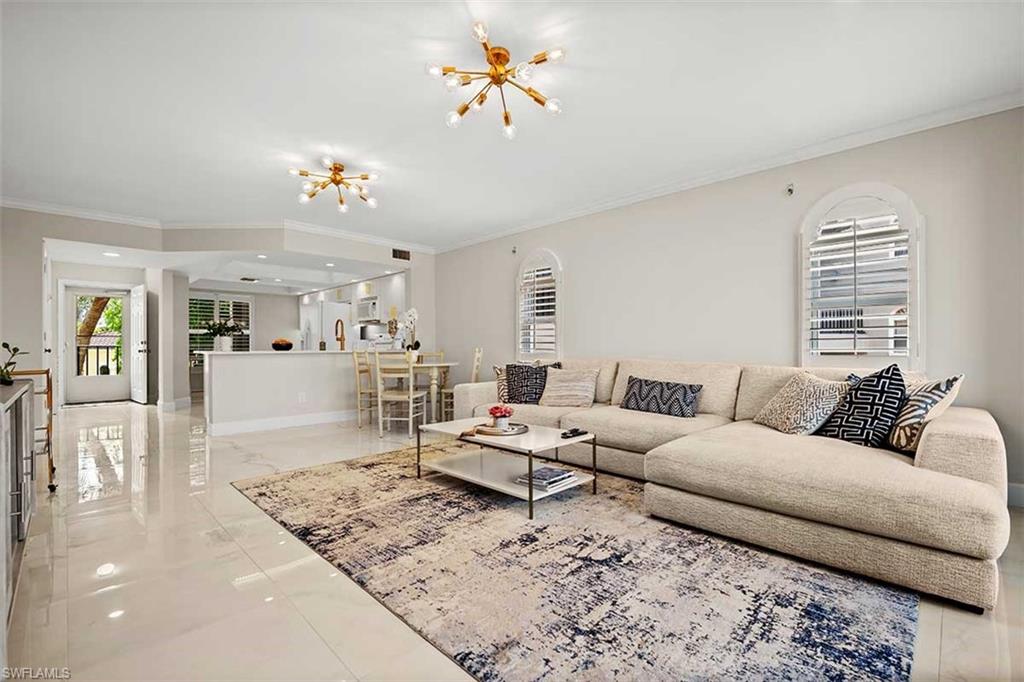 Open-concept living area featuring a kitchen pass-through with a breakfast bar, polished tile flooring, and integrated lighting fixtures