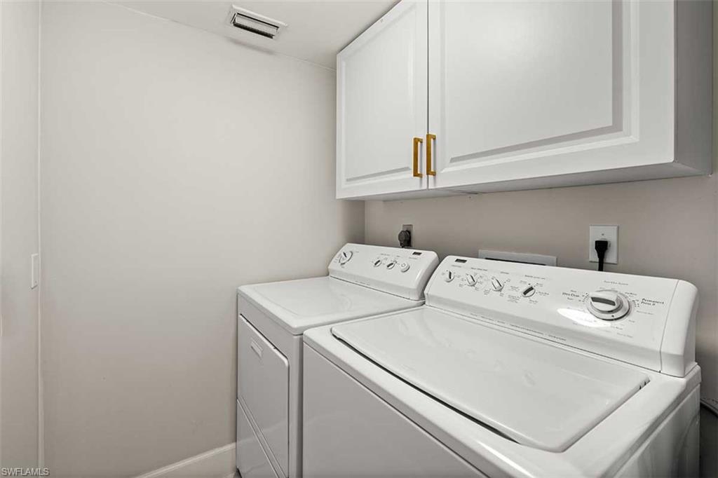 Laundry area featuring upper cabinetry with gold-tone hardware, a light-toned wall finish, and a ceiling vent