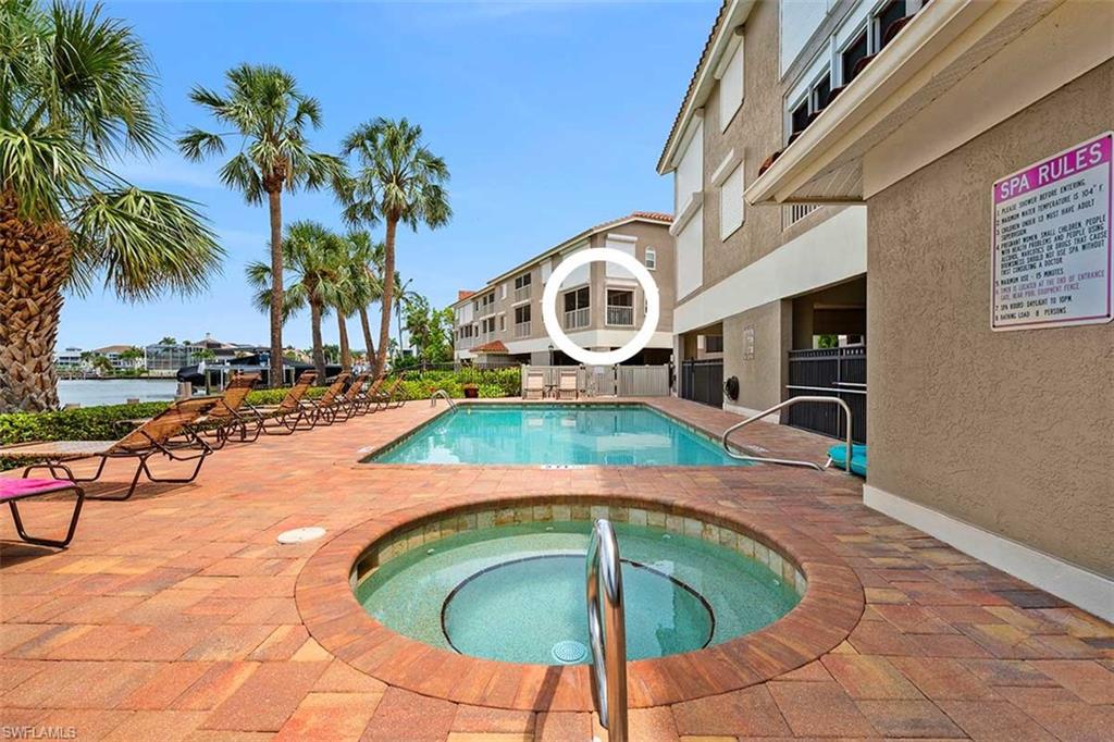 Outdoor pool area featuring a rectangular swimming pool and circular spa with integrated steps
