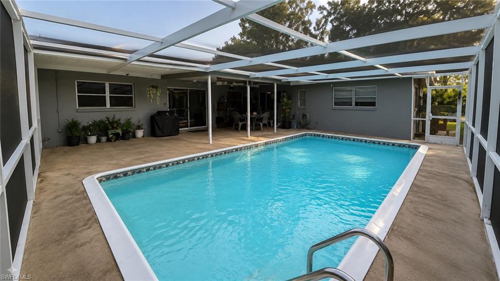 Screened pool enclosure featuring a rectangular swimming pool, concrete patio, and direct access to the interior via sliding glass doors