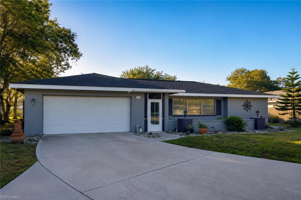 Single-story residence featuring a gray exterior, a white garage door, and a concrete driveway
