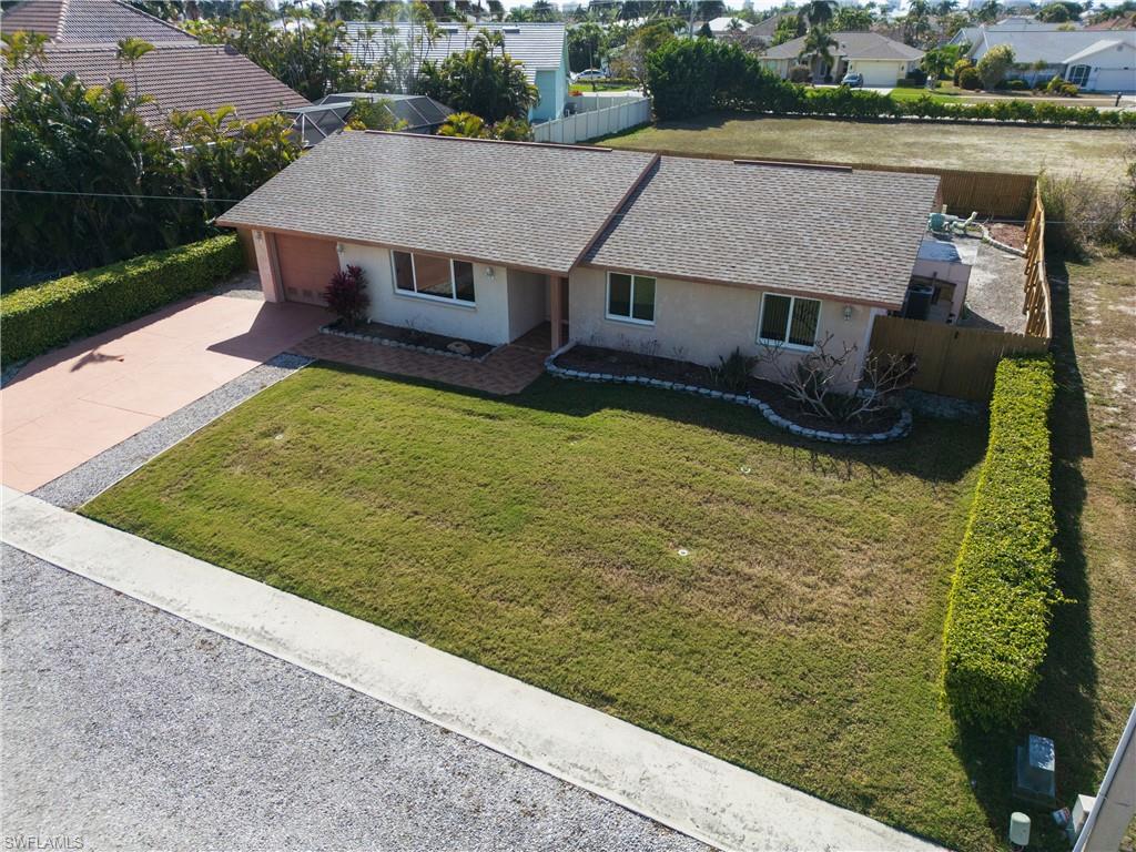 Single story home featuring stucco siding, driveway, roof with shingles, and a garage
